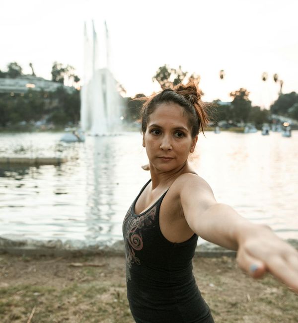 Person stretching deeply in a yoga pose against a sunset.