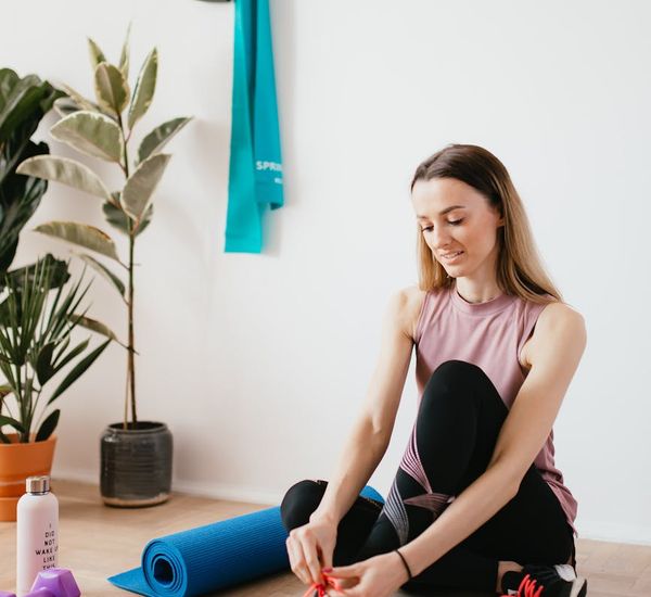 Yoga mat rolled up next to a water bottle in a calm studio.